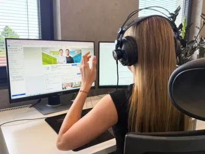 Członkini zespołu APZ pracująca zdalnie z klientem przy kilku monitorach
