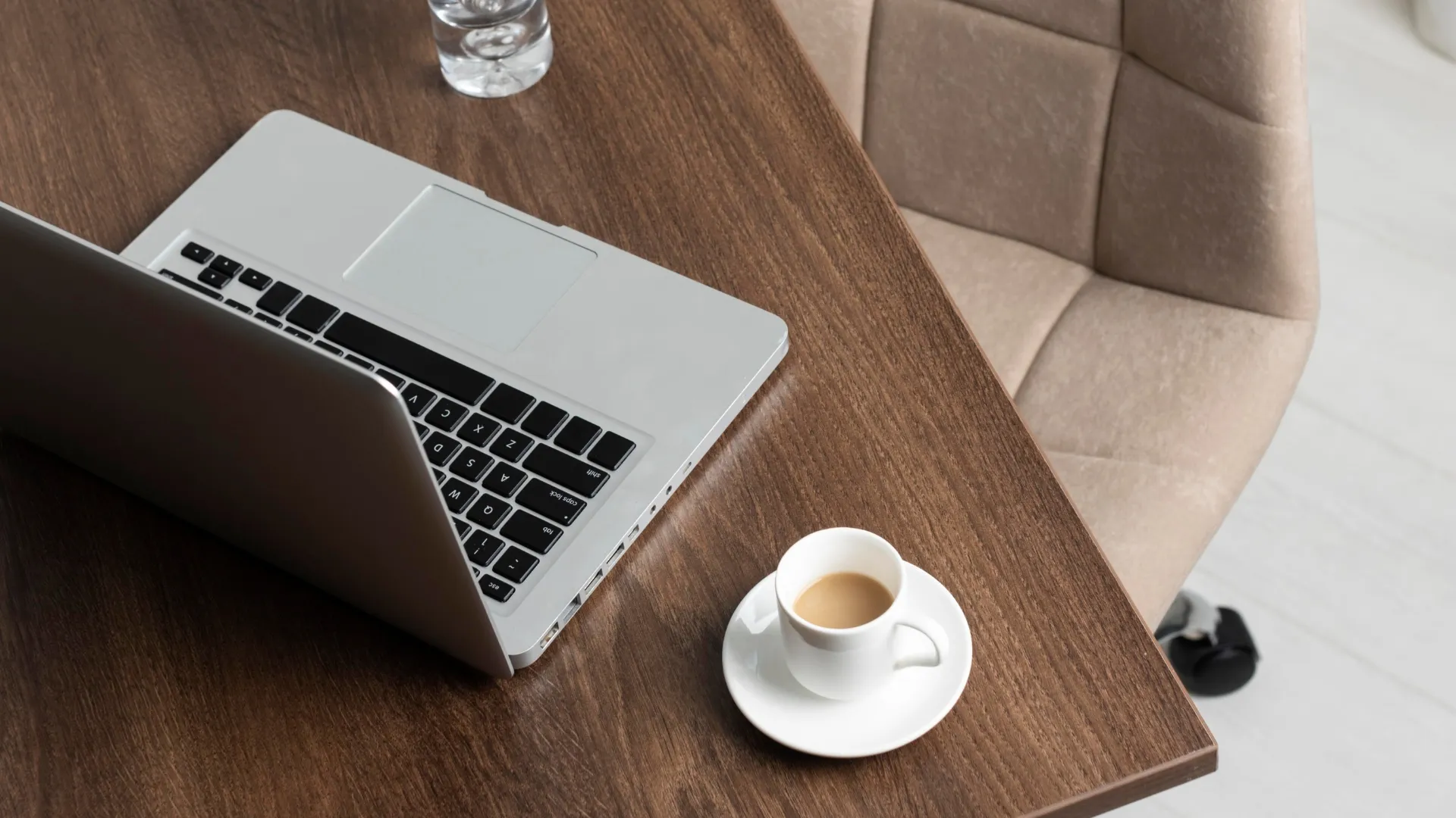 Biurko z laptopem i filiżanką kawy - wybór między gabinetem dietetycznym w przychodni a własnym lokalem