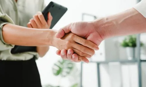 Uścisk dłoni pieczętujący współpracę zespołu wspierającego prowadzenie gabinetu dietetycznego